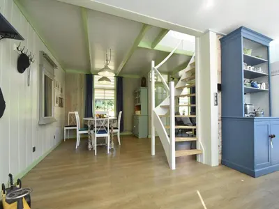 a room with a staircase and a dining room with a table at Cottage in Edam near IJsselmeer Lake in Edam