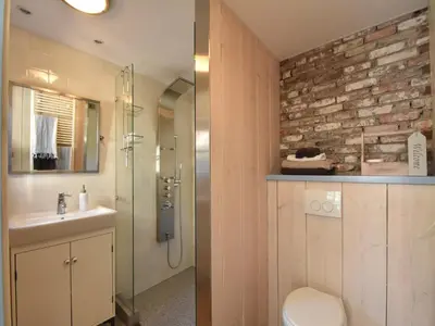 a bathroom with a toilet and a glass shower at Cottage in Edam near IJsselmeer Lake in Edam