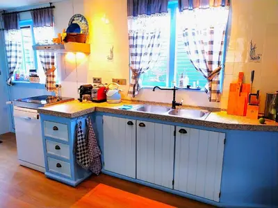 a kitchen with white cabinets and a sink at Cottage in Edam near IJsselmeer Lake in Edam
