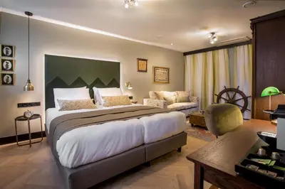 a bedroom with a large bed and a couch at The Hendrick's Hotel in Amsterdam