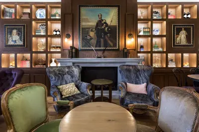 a living room with chairs and a fireplace at The Hendrick's Hotel in Amsterdam