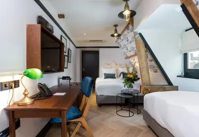 a hotel room with a desk and a bed at The Hendrick's Hotel in Amsterdam