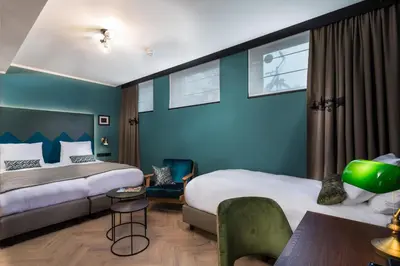 a hotel room with two beds and a table at The Hendrick's Hotel in Amsterdam