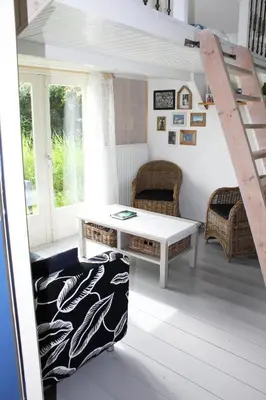 a living room with a table and chairs and a ladder at Bed and Stay Amsterdam in Amsterdam