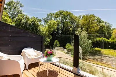 a deck with chairs and a table and a view at Duinappartementen Schoorl in Schoorl