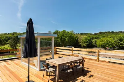 a wooden deck with a table and an umbrella at Duinappartementen Schoorl in Schoorl