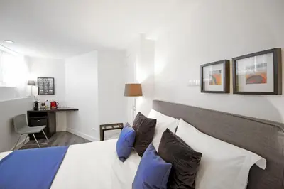 a bedroom with a bed with blue and white pillows at Guesthouse Prinsencanal 1 in Amsterdam