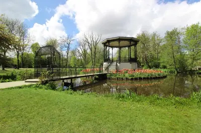 a bridge over a pond with flowers in a park at Guesthouse Prinsencanal 1 in Amsterdam