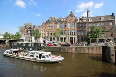 a boat traveling down a river in a city at Guesthouse Prinsencanal 1 in Amsterdam