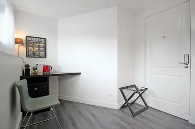 a small kitchen with a table and a green chair at Guesthouse Prinsencanal 1 in Amsterdam