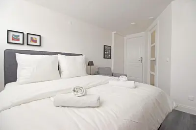 a white bed with two towels on top of it at Guesthouse Prinsencanal 2 in Amsterdam