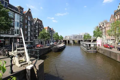 a river with boats in a city with buildings at Guesthouse Prinsencanal 2 in Amsterdam