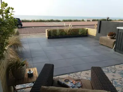 a patio with chairs and a table on a roof at Benny's Beach House 1 in Zandvoort