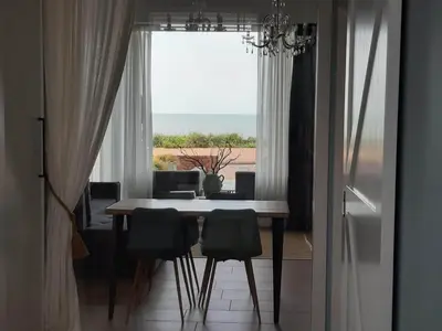 a dining room with a table and chairs and a window at Benny's Beach House 1 in Zandvoort