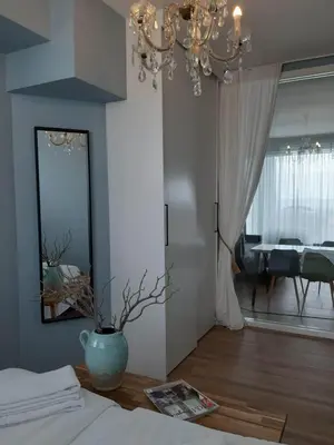 a bedroom with a vase on a table and a mirror at Benny's Beach House 1 in Zandvoort