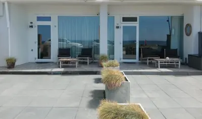 a building with a patio with chairs and tables at Benny's Beach House 1 in Zandvoort