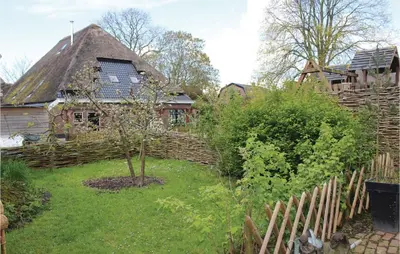 a garden with a fence and a tree in front of a house at De Bedstee in Opperdoes