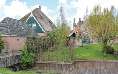 a house with a fence in front of a yard at De Bedstee in Opperdoes