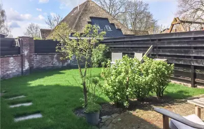 a garden with two trees in front of a building at De Bedstee in Opperdoes