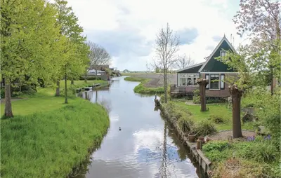 a river with a house on the side of it at De Bedstee in Opperdoes