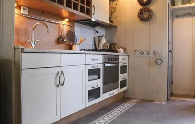 a kitchen with white cabinets and a sink at De Bedstee in Opperdoes