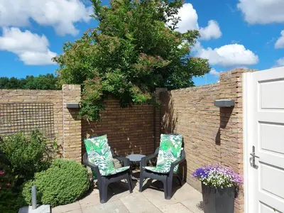 a patio with two chairs and a table in front of a brick wall at Holiday Home Canal View in Alkmaar