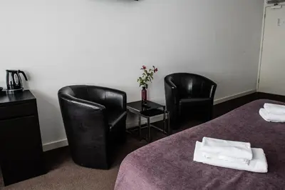 a hotel room with two chairs and a table and two beds at Hotel de Gaaper in Amersfoort