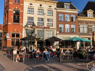 a group of people sitting at tables in front of a building at Hotel de Gaaper in Amersfoort