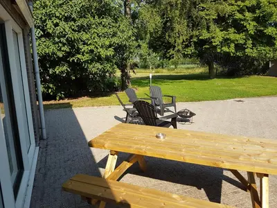 a wooden picnic table and chairs on a patio at Guest House Ons Hoekje in Houten