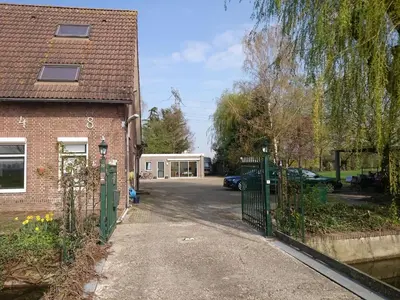 a house with a gate in front of a driveway at Guest House Ons Hoekje in Houten
