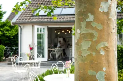 a group of tables and chairs in front of a house at Boutique hotel Villa Oldenhoff in Abcoude