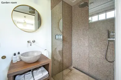a bathroom with a sink and a shower with a mirror at Boutique hotel Villa Oldenhoff in Abcoude