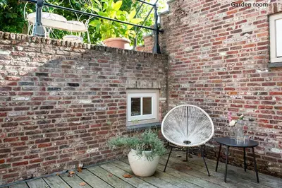 a brick wall with two chairs and a fan at Boutique hotel Villa Oldenhoff in Abcoude