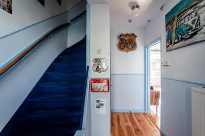 a hallway with a blue staircase in a house at Pension Sixtysix in Zandvoort