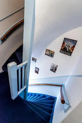 a spiral staircase with pictures on the wall at Pension Sixtysix in Zandvoort