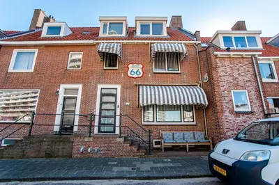 a red brick building with a sign on it at Pension Sixtysix in Zandvoort