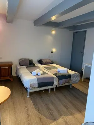 two twin beds in a room with a table at Hotel Restaurant Old Bridge in Amsterdam