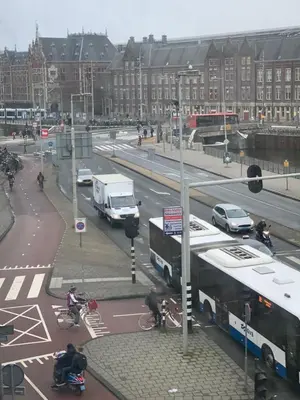 a busy city street with cars and buses and people at Hotel Restaurant Old Bridge in Amsterdam