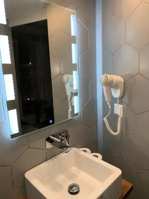a bathroom with a sink and a mirror and a phone at Hotel Restaurant Old Bridge in Amsterdam