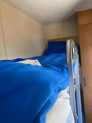 a bedroom with two bunk beds with blue sheets at Chalet Jade in IJmuiden