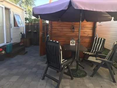 a table and chairs under an umbrella on a patio at Chalet Jade in IJmuiden