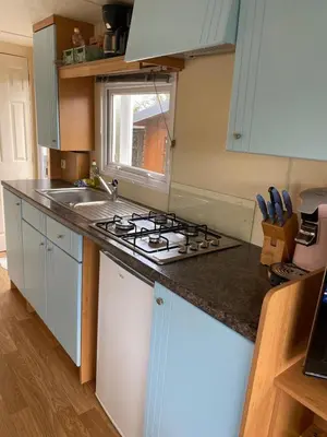 a kitchen with a stove and a sink at Chalet Jade in IJmuiden