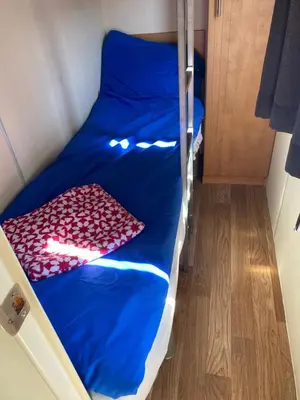 a bed with blue sheets and a bunch of red hearts at Chalet Jade in IJmuiden