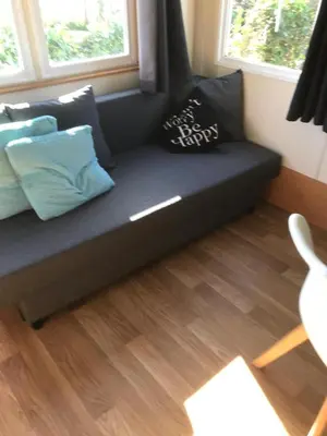 a couch in a living room with pillows on it at Chalet Jade in IJmuiden