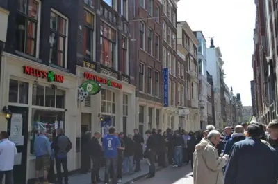 a crowd of people walking down a city street at Amsterdam Red Light Bed & Breakfast in Amsterdam