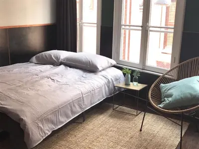 a bedroom with a bed and two chairs and windows at Amsterdam Red Light Bed & Breakfast in Amsterdam