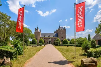 a house with two red flags in front of it at Stayokay Hostel Heemskerk - fully renovated April 2026 in Heemskerk