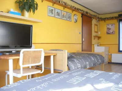 a bedroom with a bed and a desk with a television at B&B-Edam in Edam