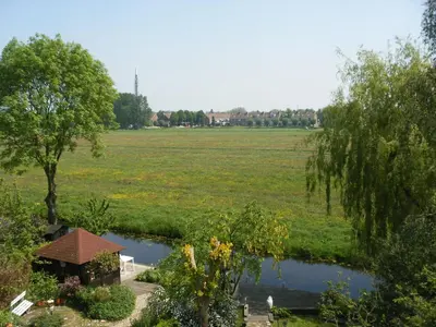 a view of a field and a pond in a field at B&B-Edam in Edam