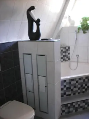 a bathroom with a toilet and a shower with a statue at B&B-Edam in Edam